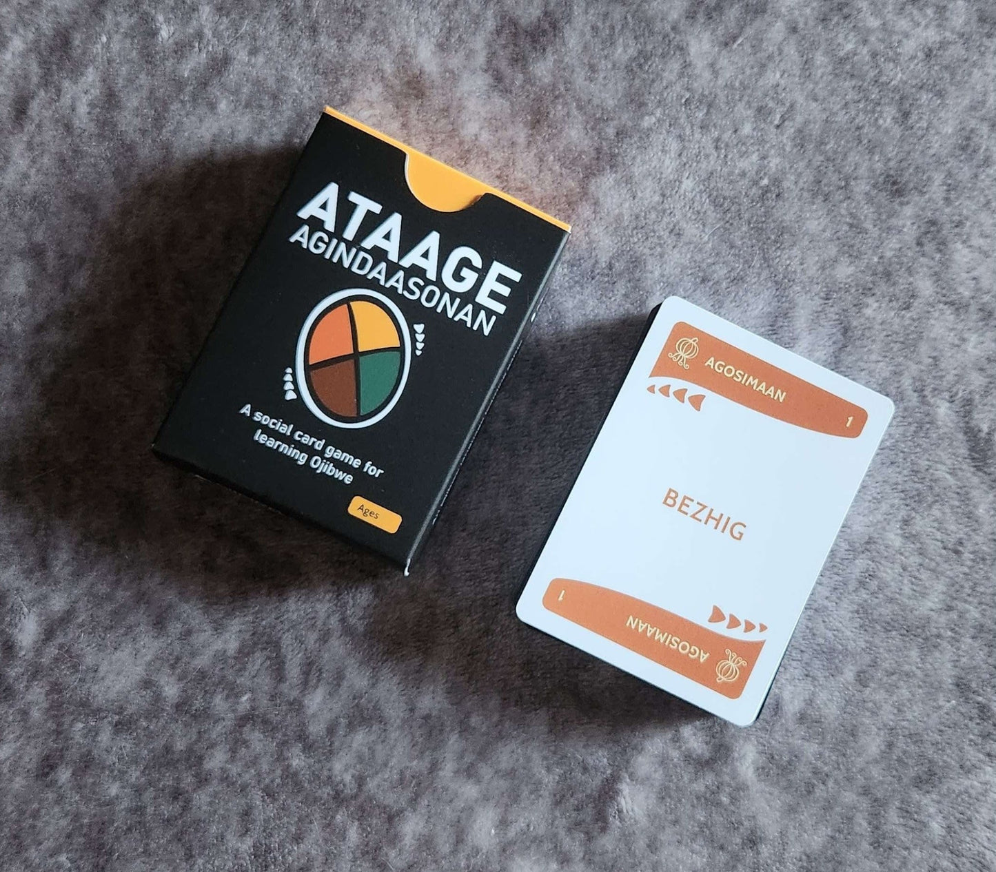 Ataage Agindaasonan an Ojibwe card deck and cards on a grey surface