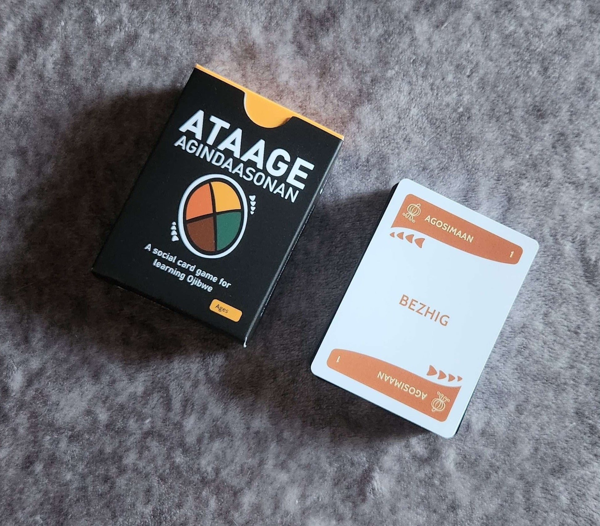 Ataage Agindaasonan an Ojibwe card deck and cards on a grey surface